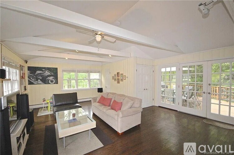 A living room with a white couch and a glass coffee table.