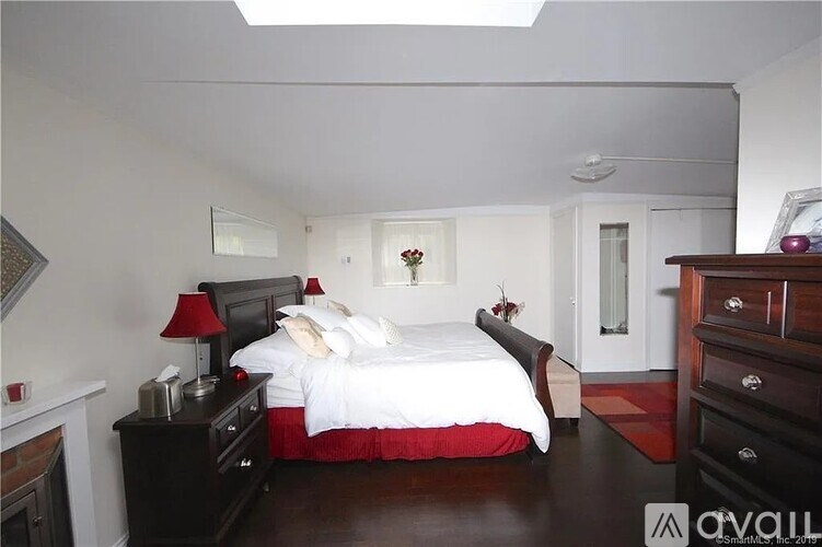 A bedroom with a bed, nightstand, and dresser.