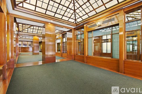 A spacious room with wooden floors and ceiling, and glass walls.