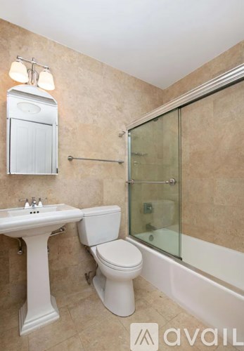 A bathroom with a toilet, sink, and shower.