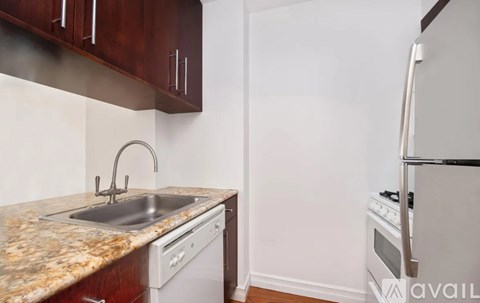 A kitchen with a granite countertop and white appliances.