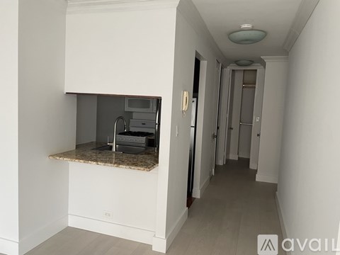 A hallway with a bench and a microwave on top of it.