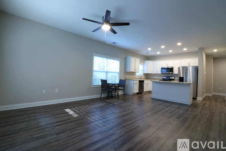 A spacious room with a ceiling fan and wooden flooring.