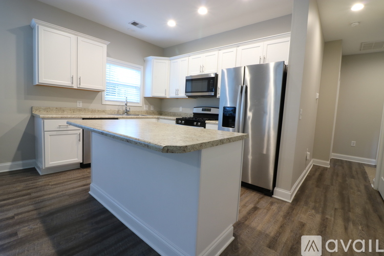 A kitchen with a granite countertop and stainless steel appliances.