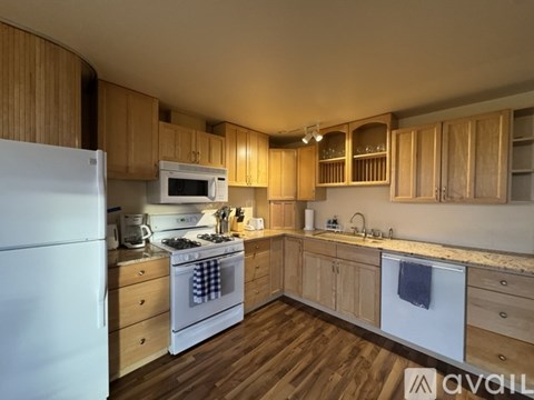 A kitchen with wooden cabinets and a white refrigerator.