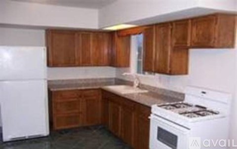 A kitchen with wooden cabinets and white appliances.