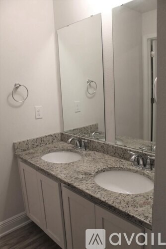 A bathroom with granite countertops and two sinks.