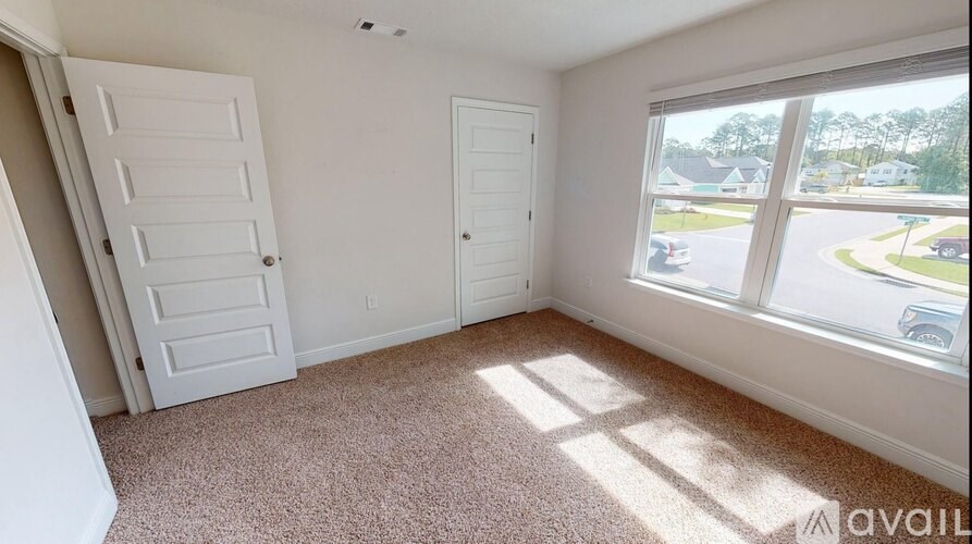 A room with two doors and a carpeted floor.