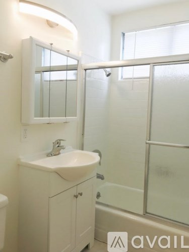A white bathroom with a sink and mirror.