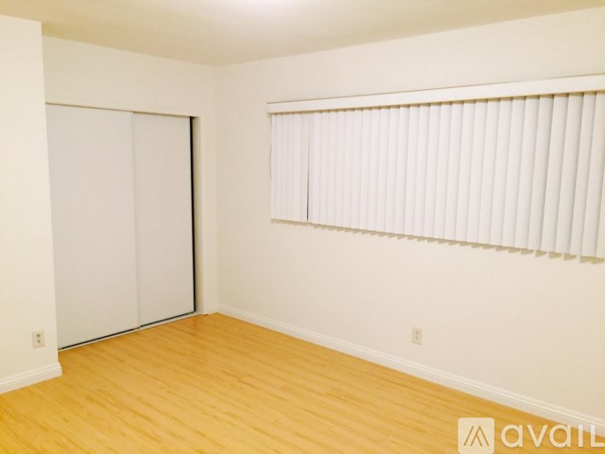 A room with a sliding door and a window with blinds.