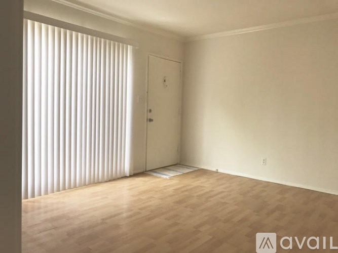 A room with a door and a window with blinds.