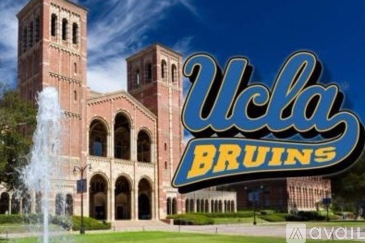 A fountain is spraying water into the air in front of a building with a sign that says UCLA Bruins.