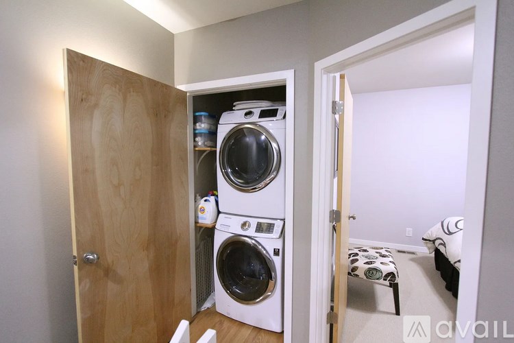 A small laundry room with a washer and dryer stacked on top of each other.