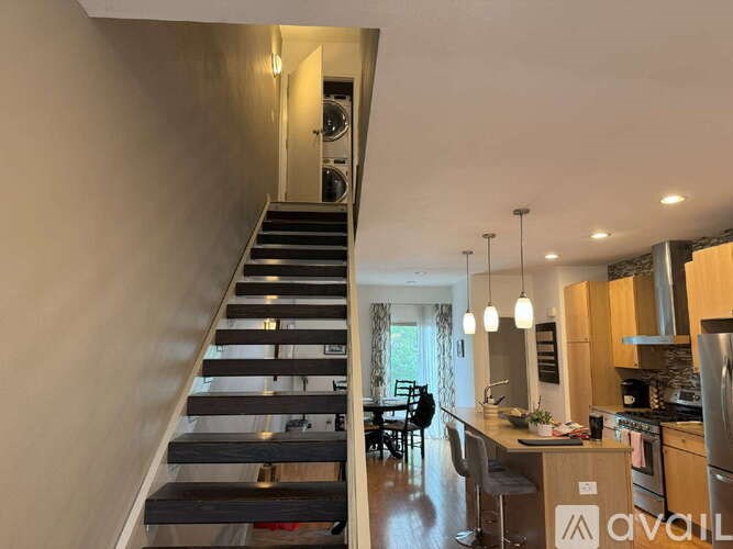 A modern kitchen with a staircase leading to the upper floor.