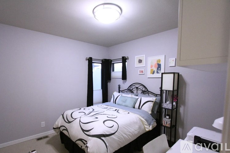 A bedroom with a bed, nightstand, and lamp.