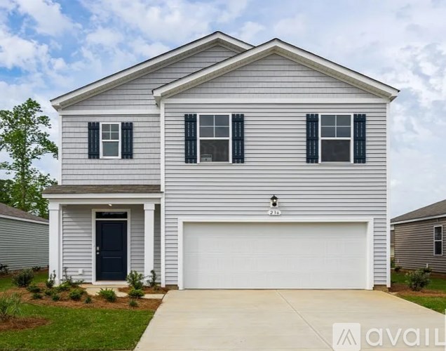A two-story house with a garage door and a black door.