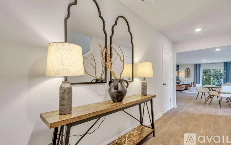 A room with a table, chairs, and lamps.