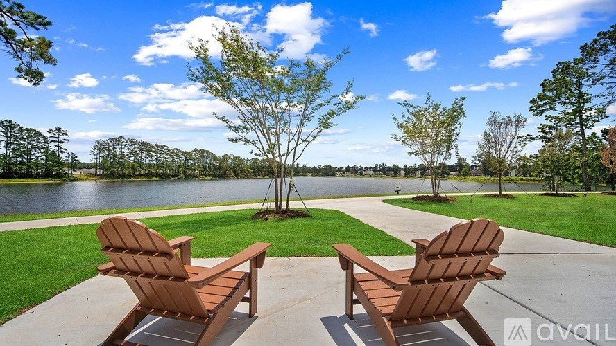 Two brown chairs are facing a lake.