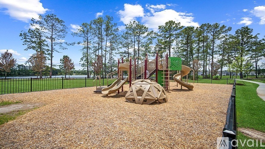 A playground with a slide, a ball and a climbing frame.