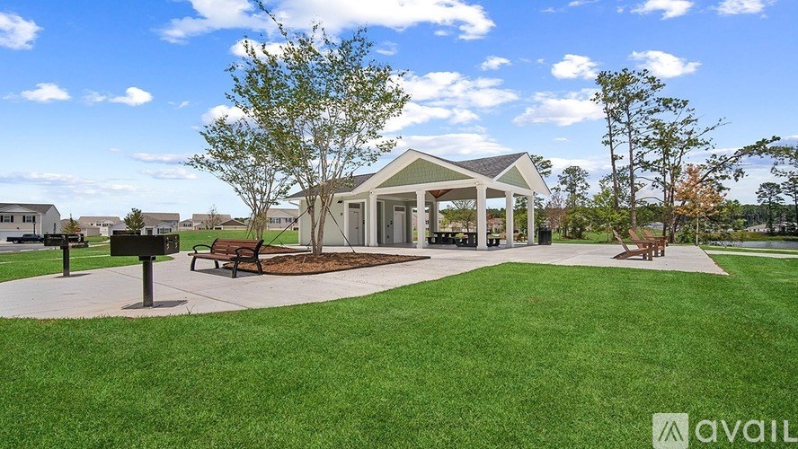 A park with a pavilion, benches, and trees.