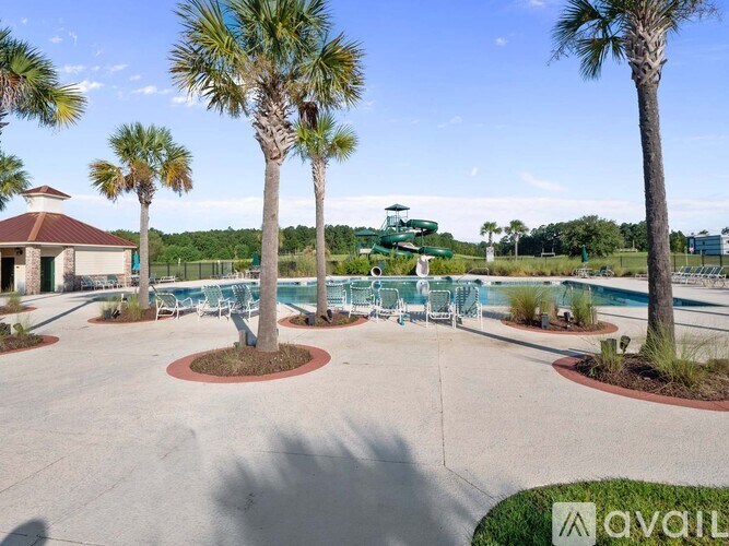 A pool surrounded by palm trees and chairs.