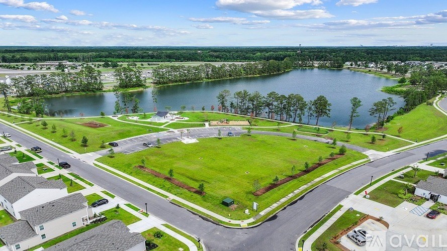 A bird's eye view of a residential area with houses, roads, and a large lake.