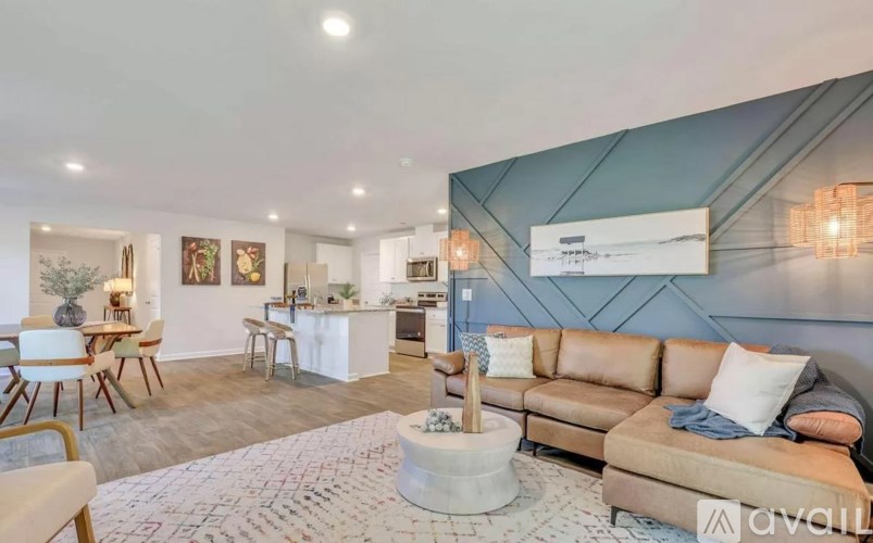 A living room with a couch, chairs, and a coffee table.