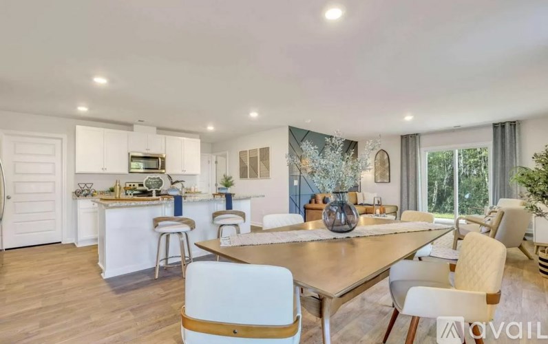 A modern kitchen with a dining table and chairs.