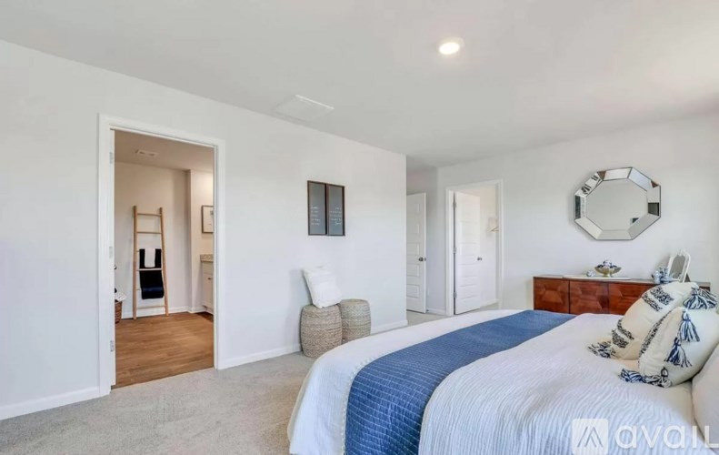 A bedroom with a large bed and a mirror on the wall.