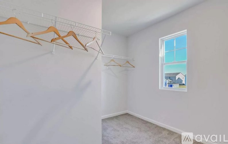 A room with a window and a wall with a picture of a house on it.