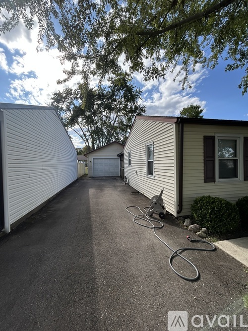 A sunny day at the mobile home with a hose on the driveway.