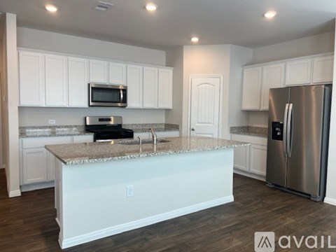 A kitchen with white cabinets and a granite countertop.