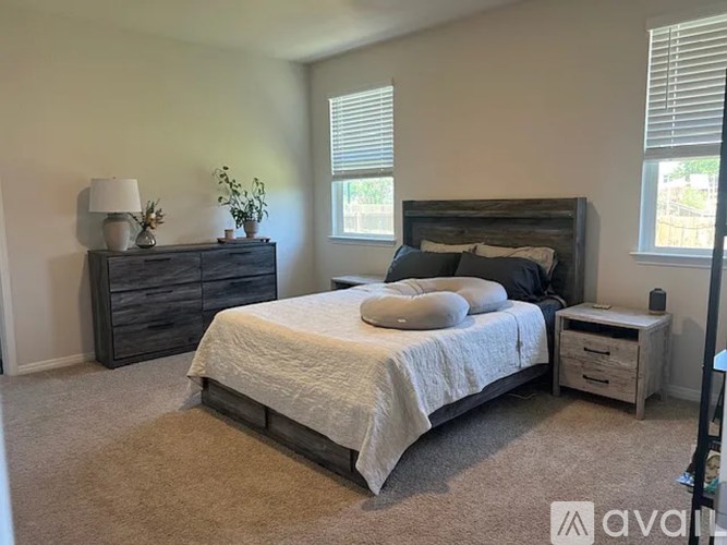 A bedroom with a bed, nightstand, and dresser.