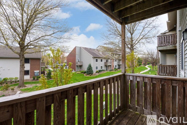 A wooden deck overlooks a residential area with houses and trees.