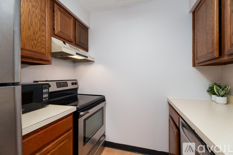 A kitchen with wooden cabinets and black appliances.