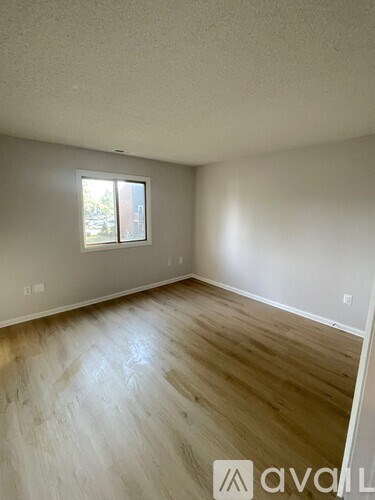 A room with wooden flooring and a window.