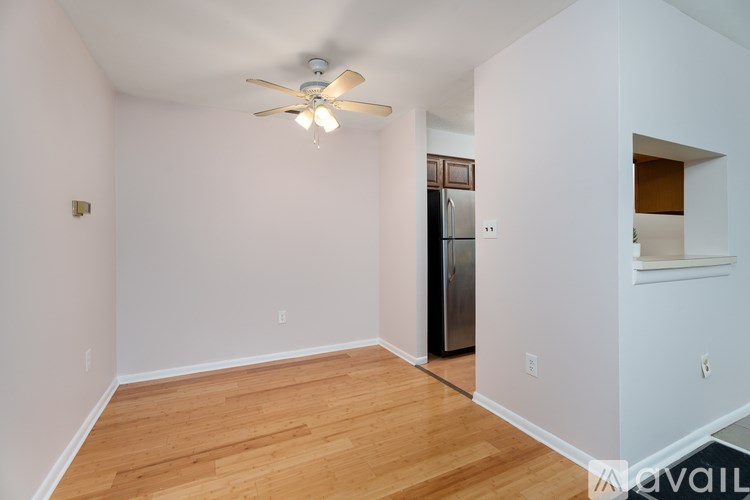 A spacious room with a ceiling fan and wooden flooring.