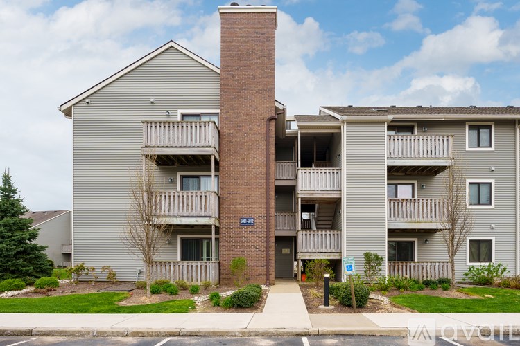 A brick chimney rises from the center of a two-story apartment building.