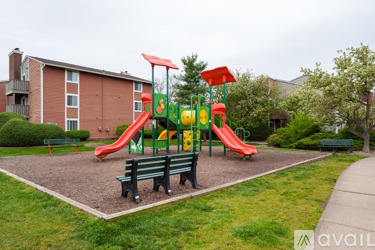 A playground with a red slide and green slide.