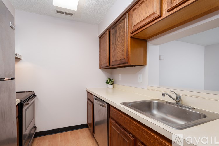 A kitchen with wooden cabinets and a stainless steel sink.