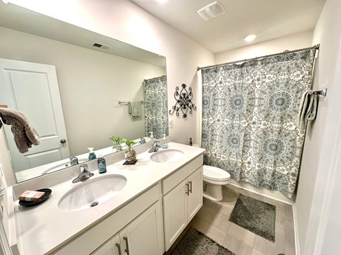 A bathroom with a white sink and a shower curtain.