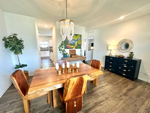 A dining room with a wooden table and chairs.