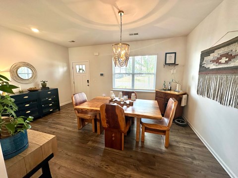 A dining room with a wooden table and chairs.