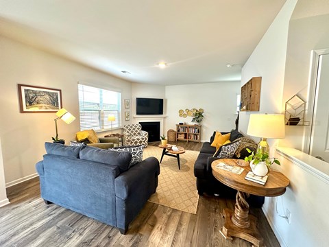 A living room with a grey couch, a wooden table, and a television.