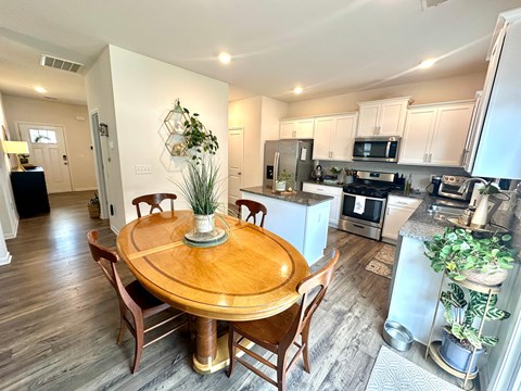 A kitchen with a table and chairs in the middle of the room.
