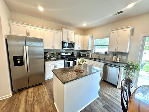 A kitchen with a granite countertop and stainless steel appliances.