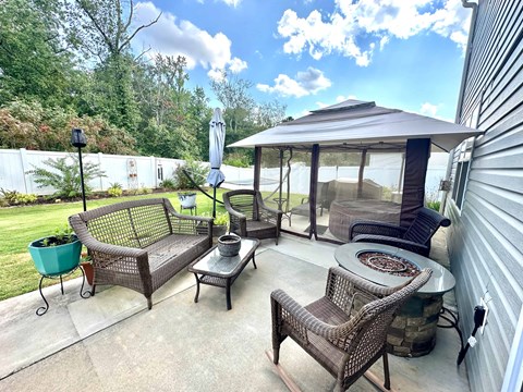 A patio with a table, chairs, and a canopy.