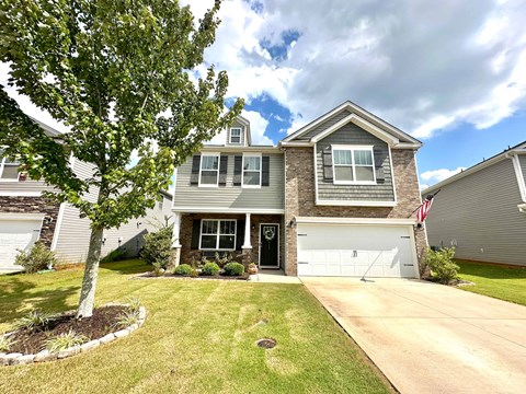 A house with a grey roof and a white garage door.