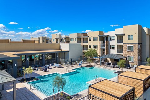 A large swimming pool is surrounded by apartment buildings.