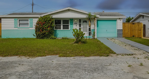 A house with a green lawn and a grey garage door.